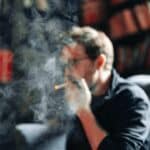 Smoking Man portrait with books in background