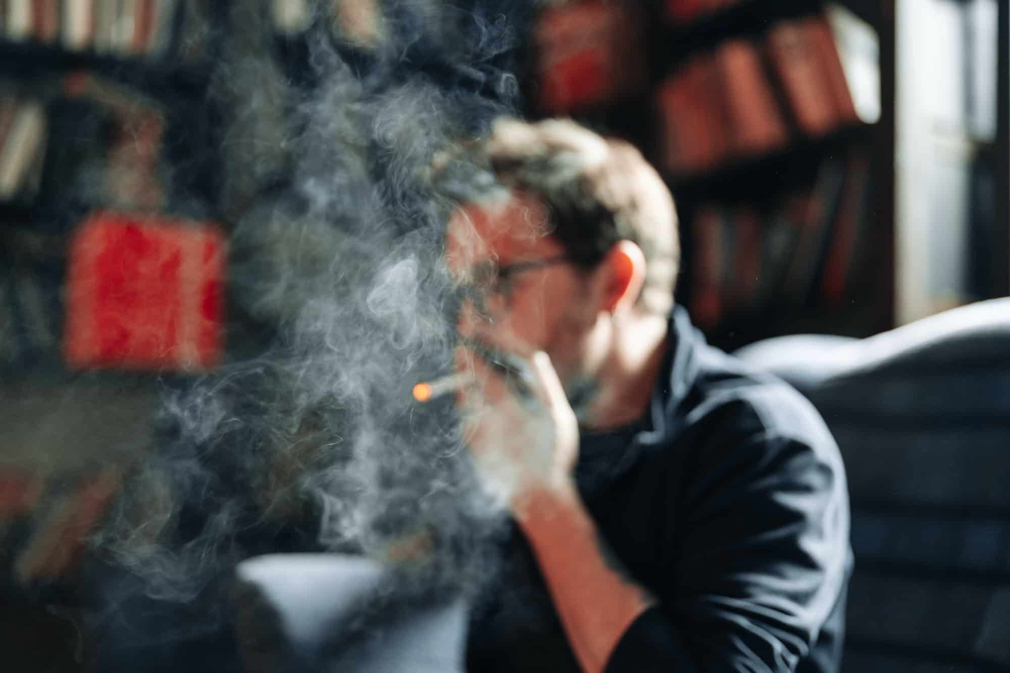 Smoking Man portrait with books in background