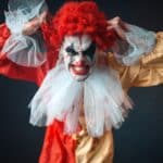 Scary bloody clown tears his hair, jerk in anger