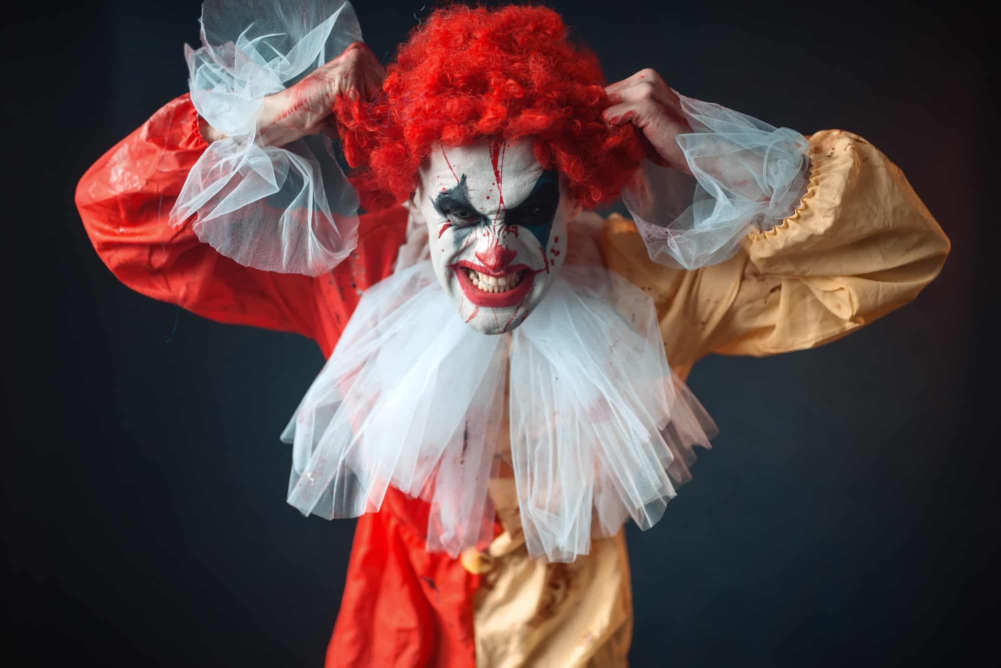 Scary bloody clown tears his hair, jerk in anger
