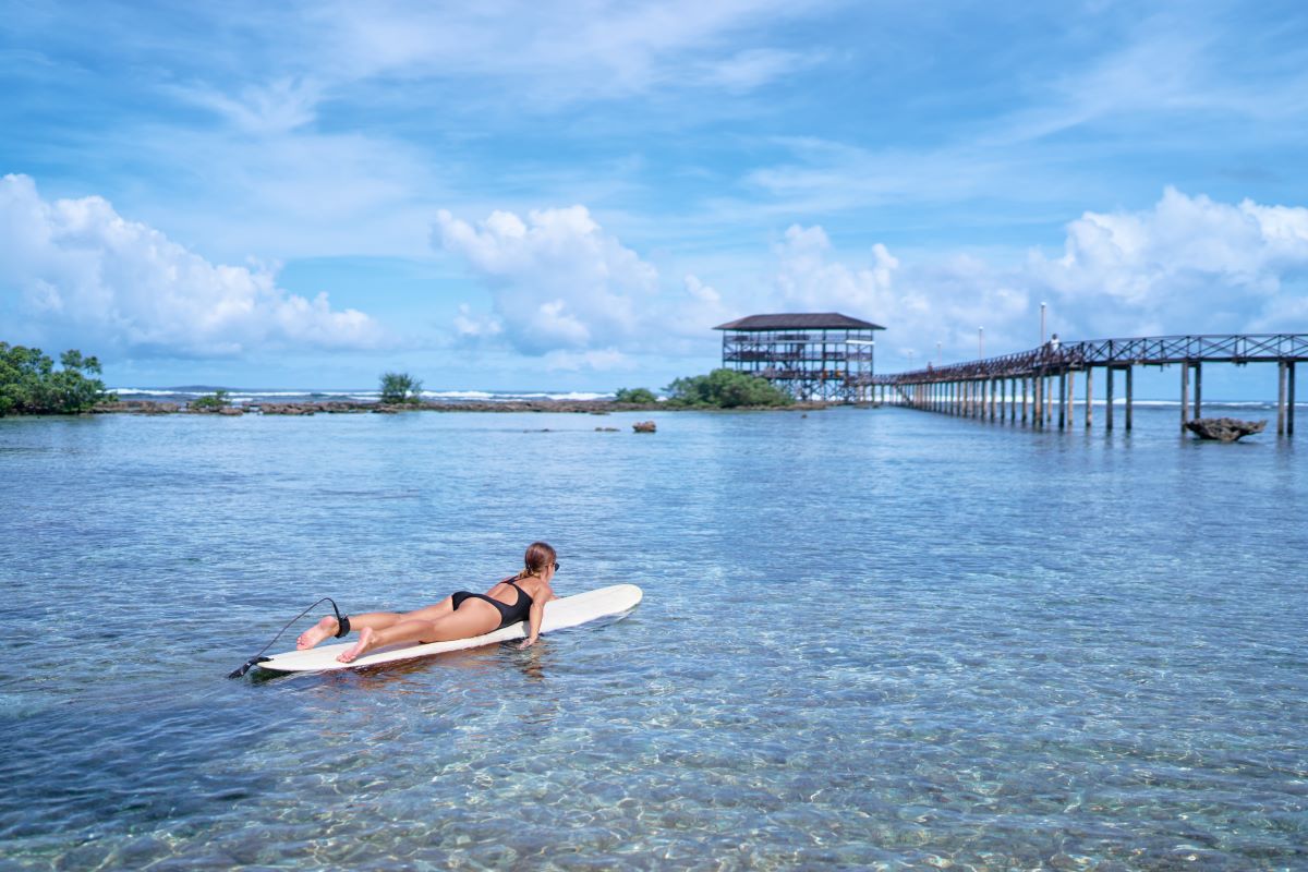 jeune surfeuse surfant en s'amusant sur cloud nine spot, siargao beach