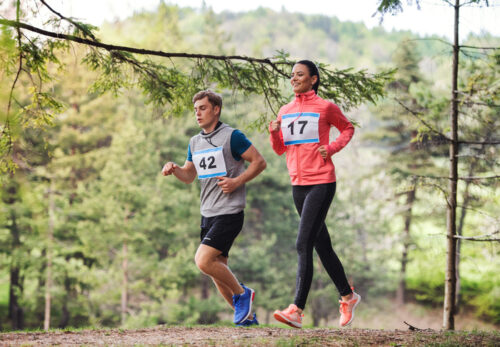 jeune couple organisant une compétition de course dans la nature.