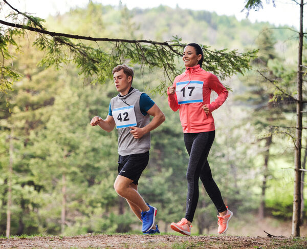 jeune couple organisant une compétition de course dans la nature.